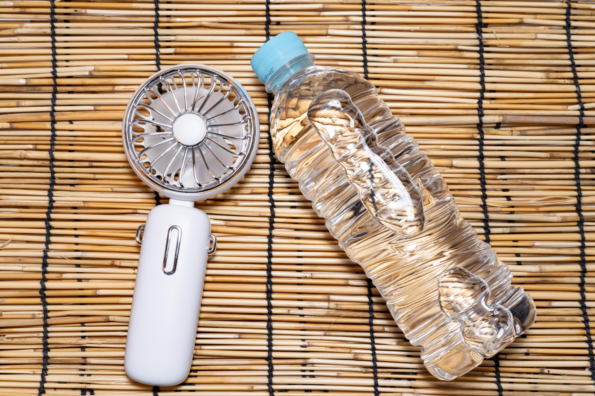 ハンディファンとペットボトルの水の画像